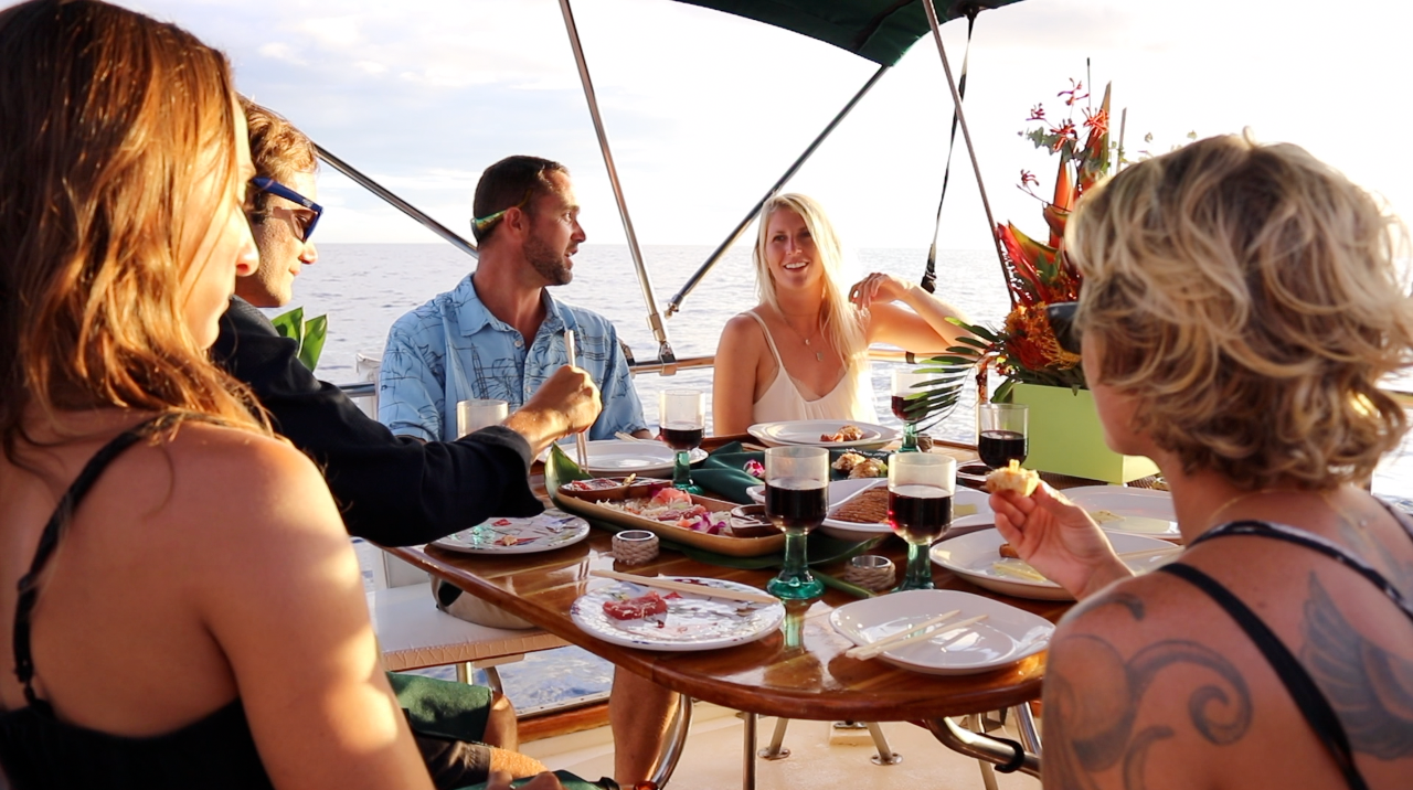 A group of people are sitting around a table eating food.
