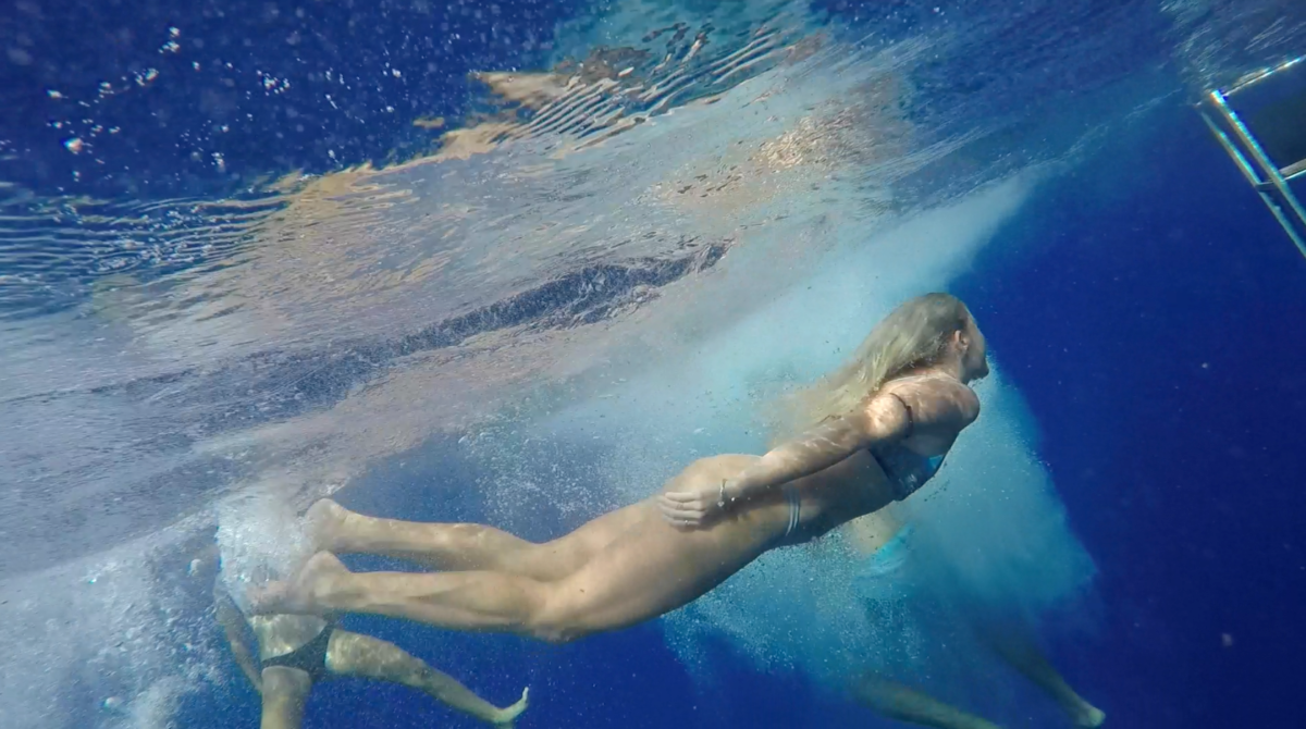 A group of people are swimming underwater in the sea.