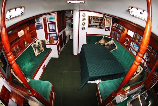 A living room on a boat with green furniture and a table