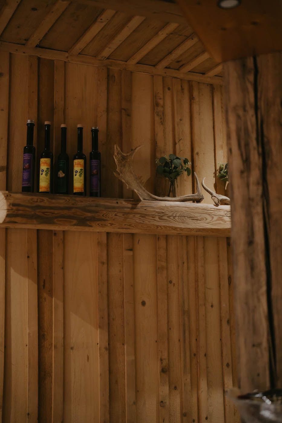 Holzregal mit Flaschen und Dekorationen.