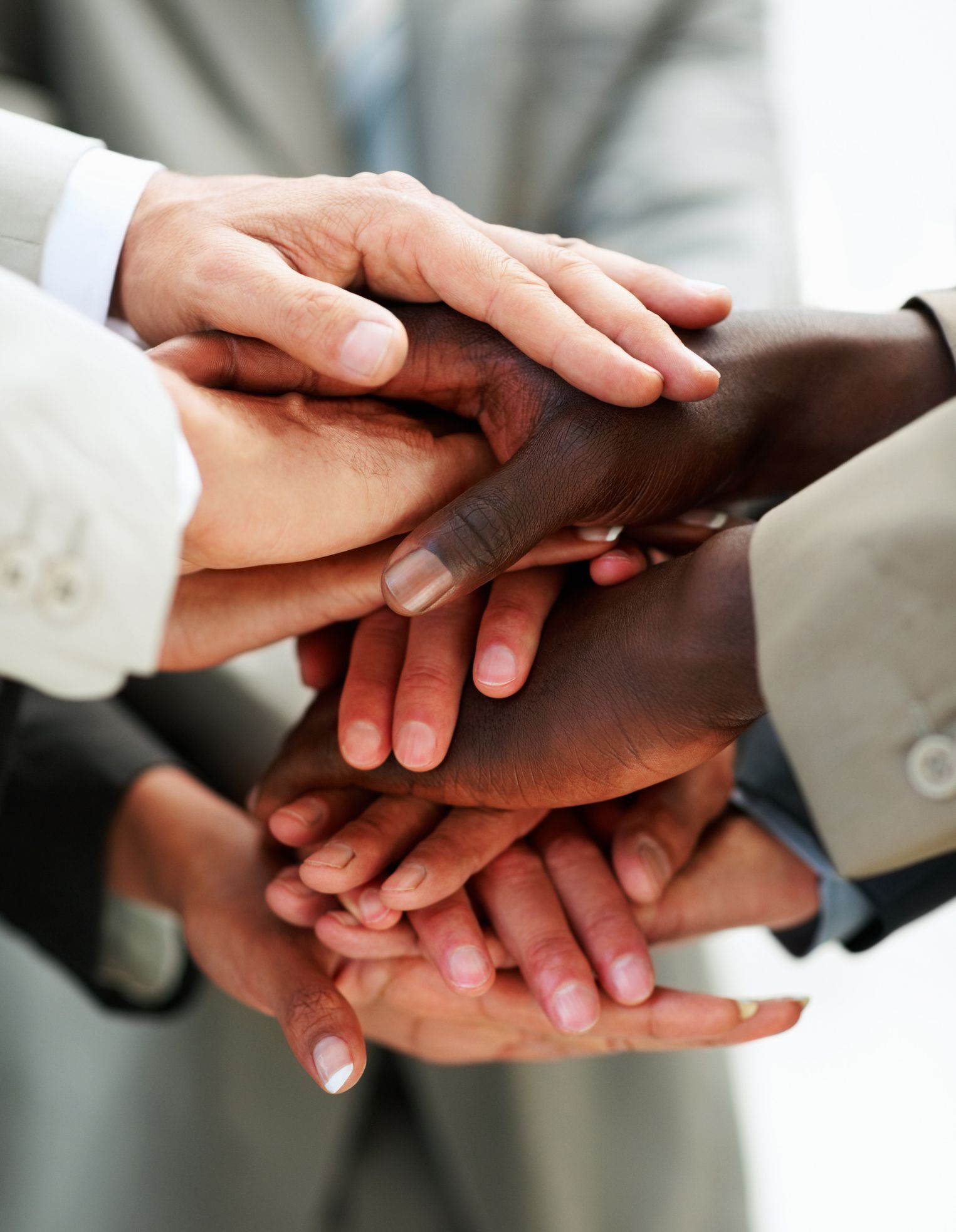 A group of people are putting their hands together