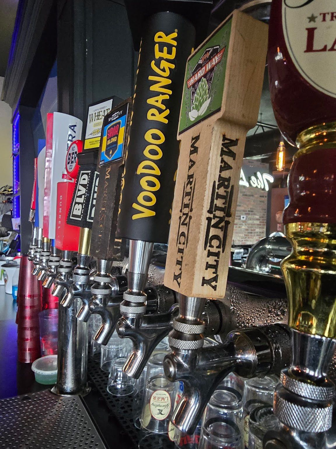 A row of beer taps with one that says voodoo ranger