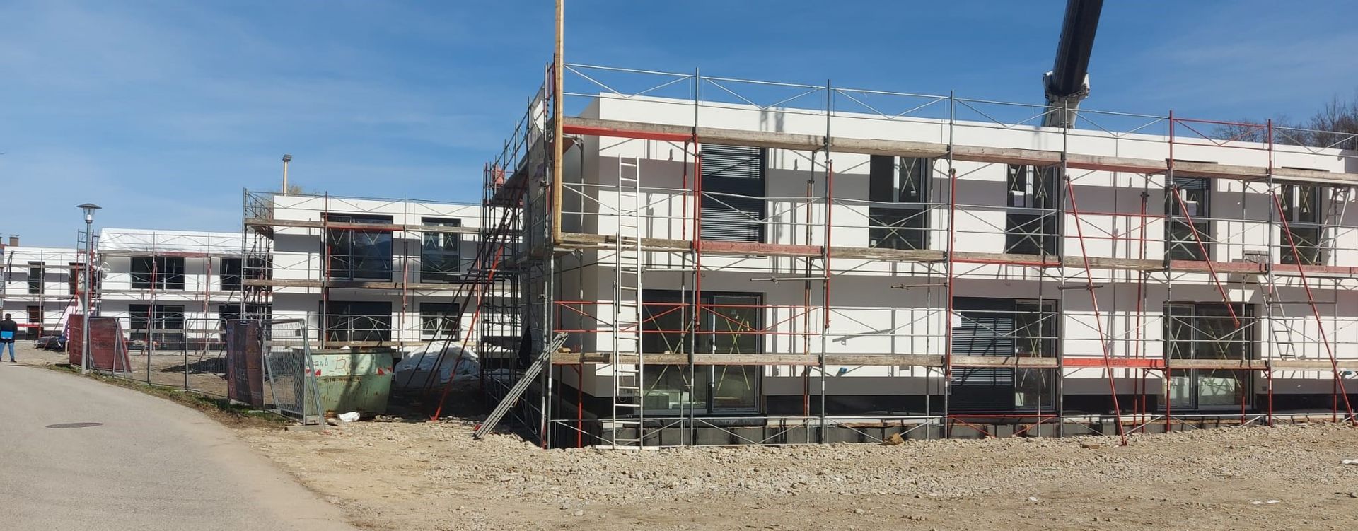 Im Bau befindliche Gebäude mit Gerüsten und Fenstern.