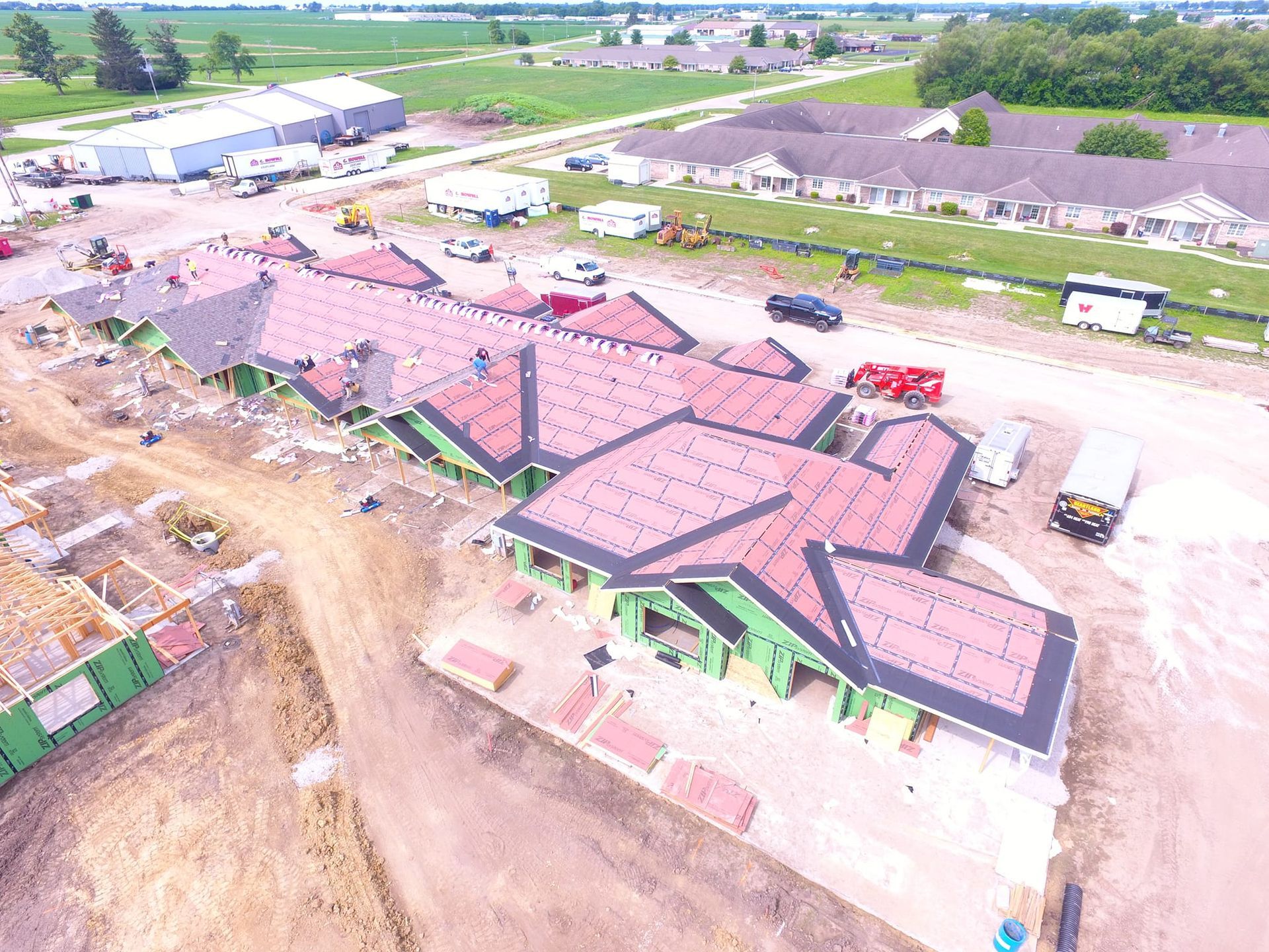 An aerial view of a building under construction with a red roof.