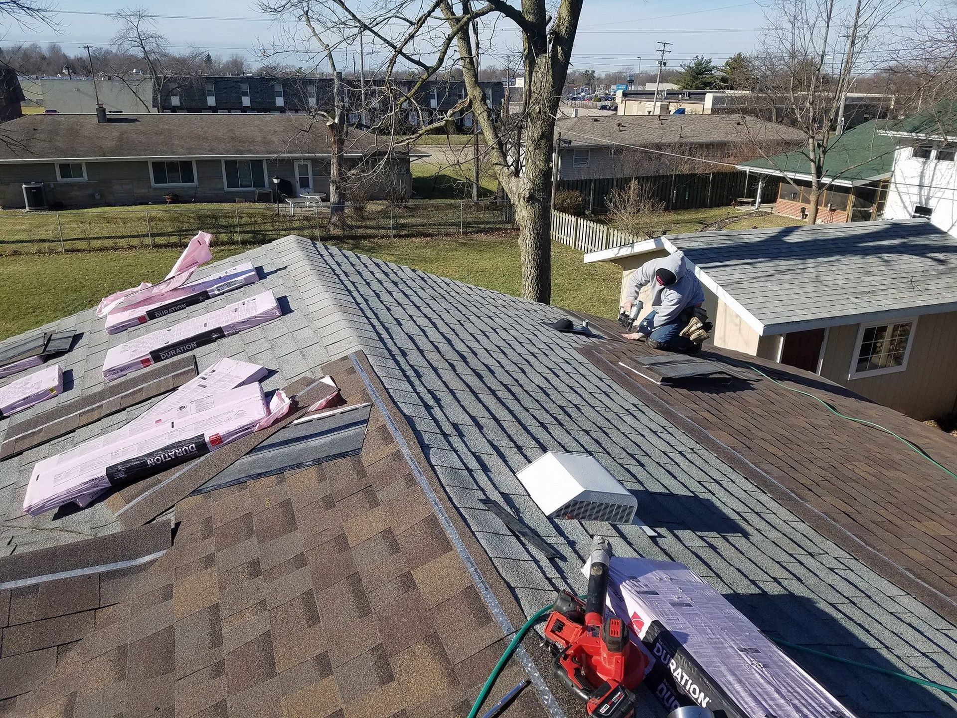 A man is working on the roof of a house.