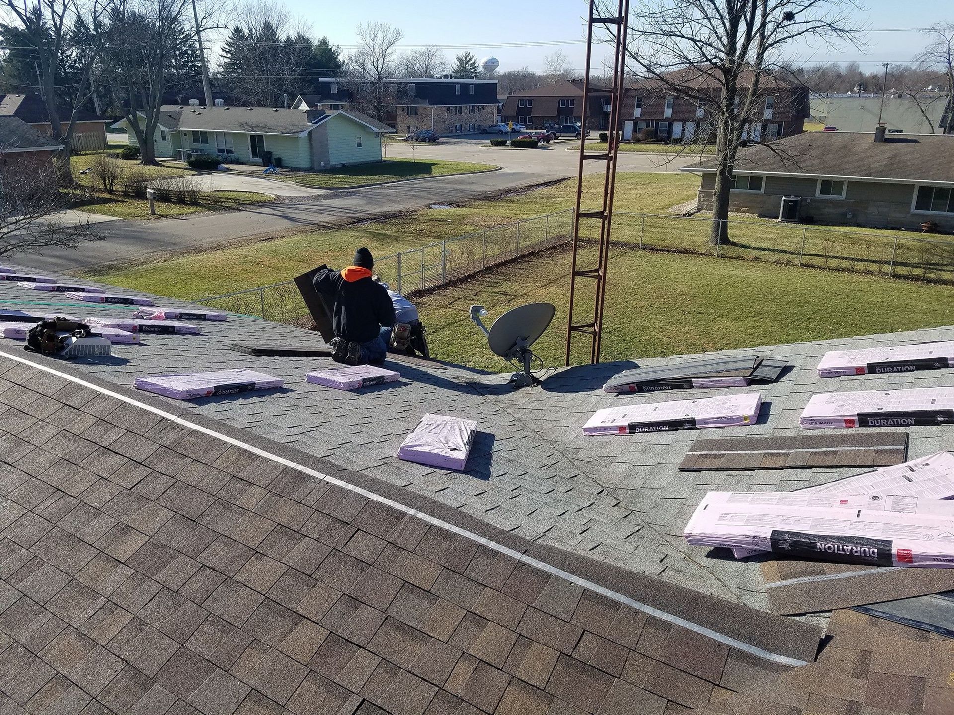 A man is working on the roof of a house.