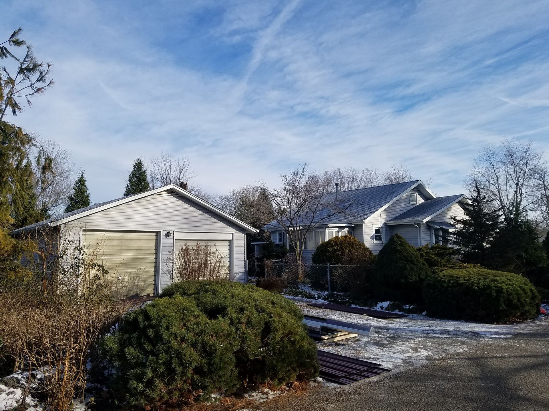A row of houses in a snowy neighborhood with a garage in the foreground.