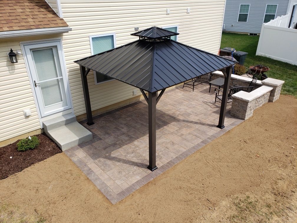 An aerial view of a gazebo on a patio in front of a house.