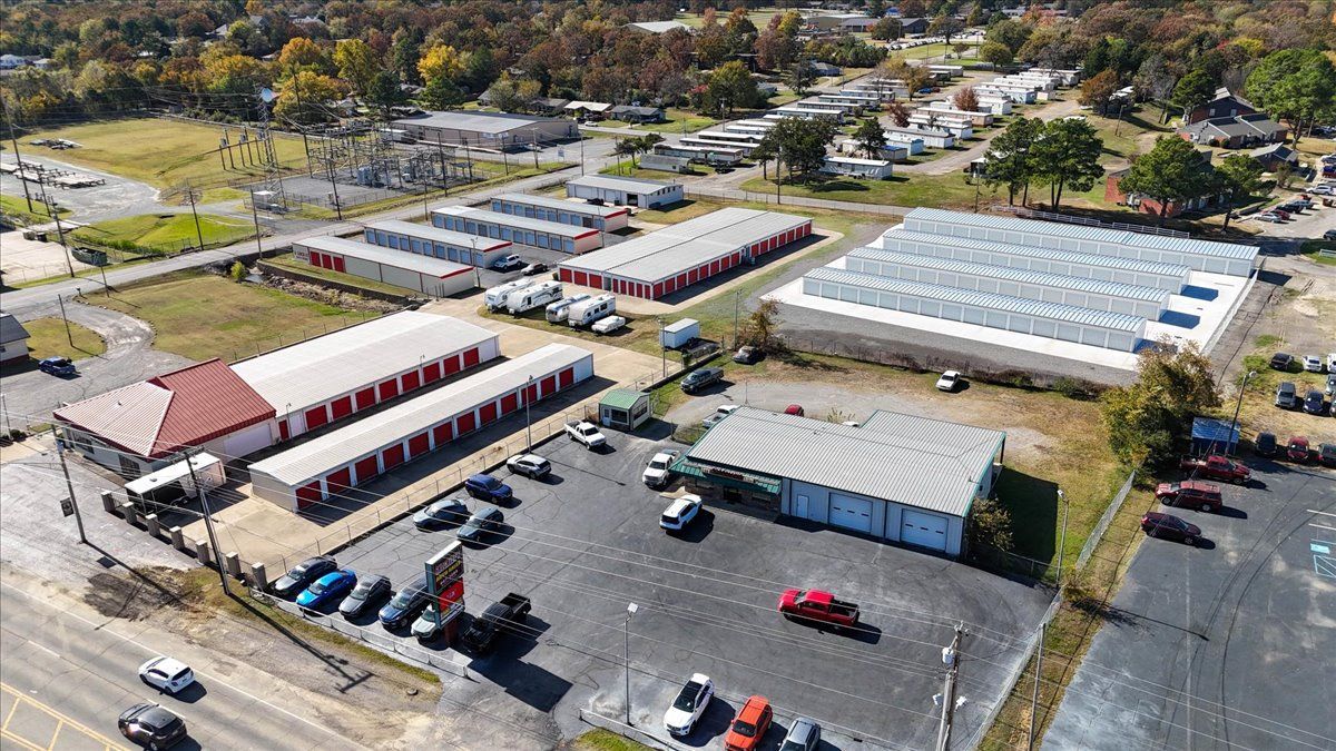 Aerial view of storage units, parking lot, and commercial buildings.