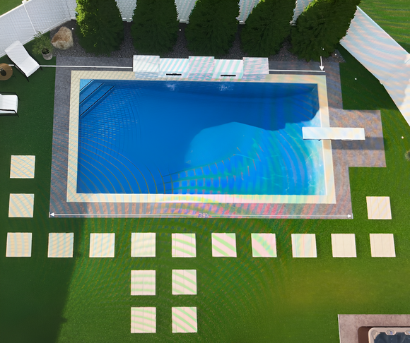 An aerial view of a bright blue rectangular swimming pool surrounded by a patio, a green lawn, and square stepping stones.