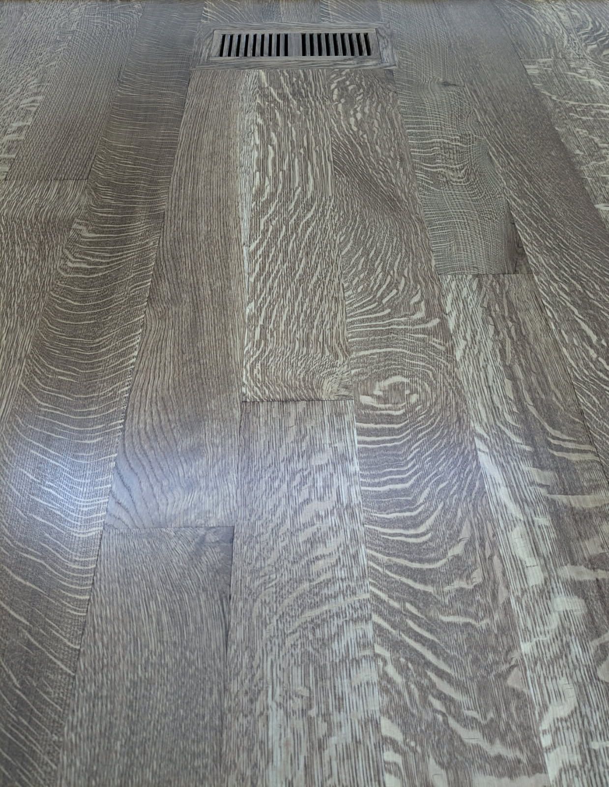 Glossy, dark hardwood floor with a rich brown finish and light reflections.