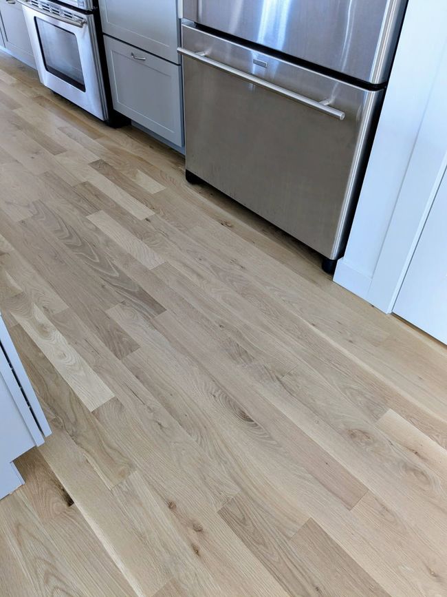 Open doorway with hardwood floors and tile inset.
