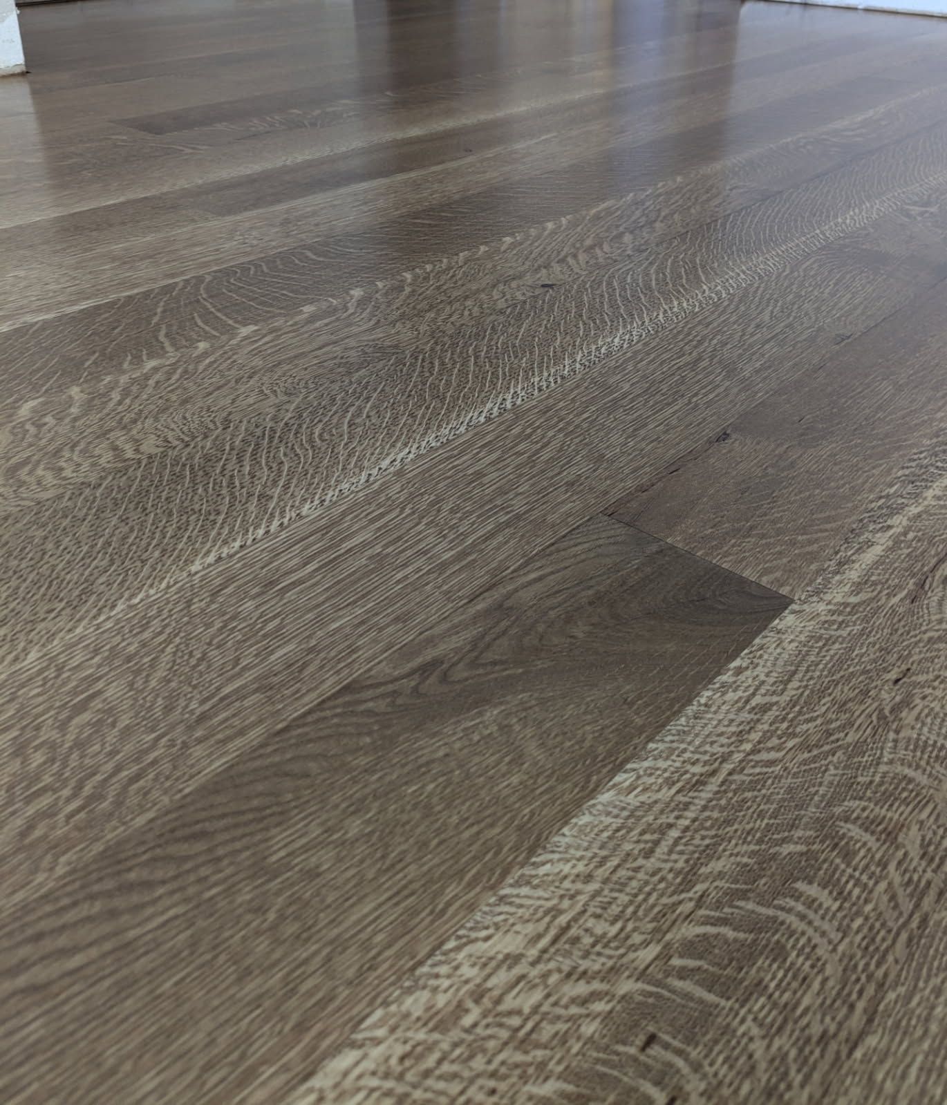 Wooden floorboards in shades of brown and tan, angled diagonally.