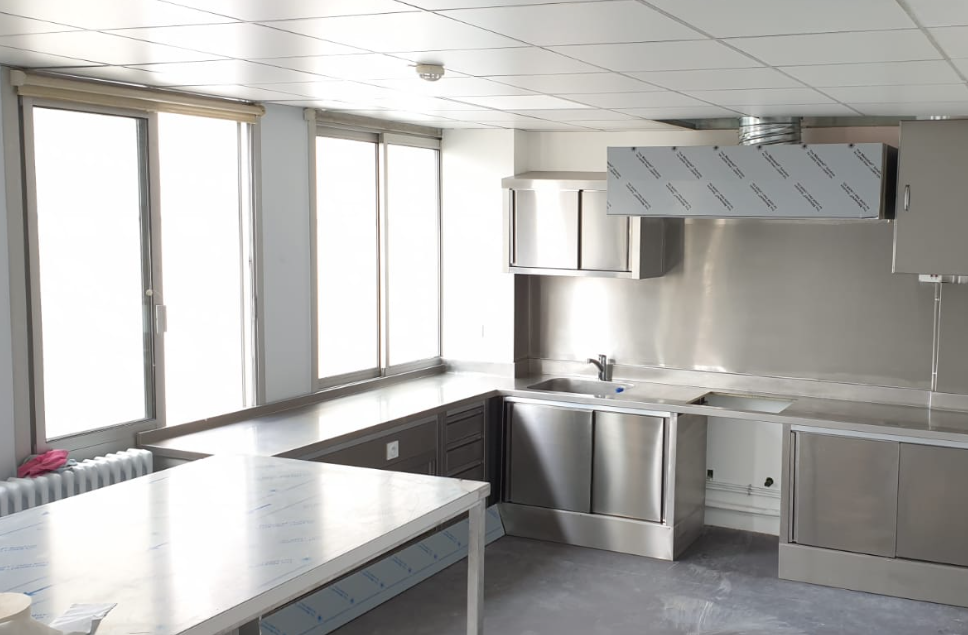 Une cuisine avec des armoires et des comptoirs en acier inoxydable