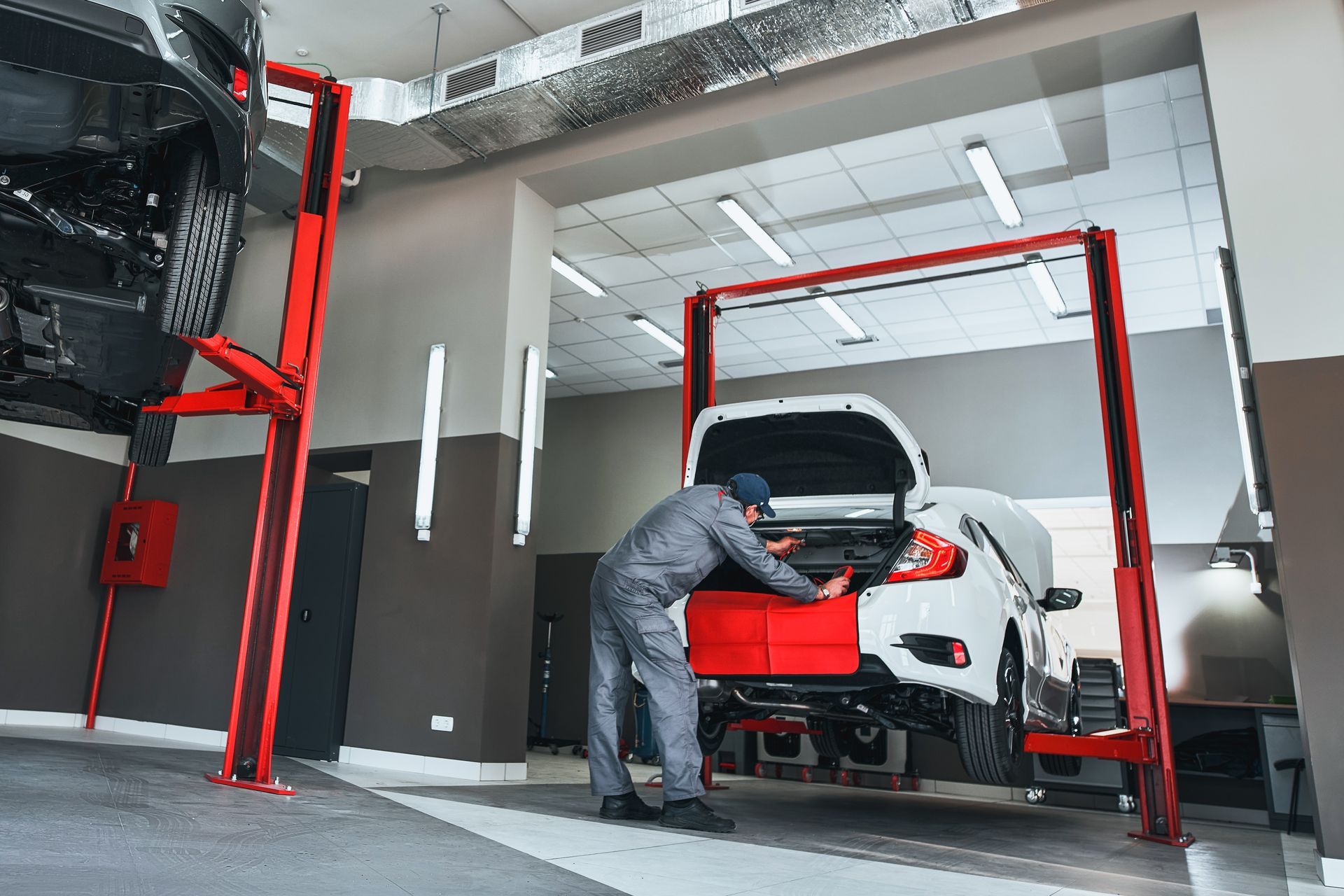 A man is cleaning a red car with a green sponge