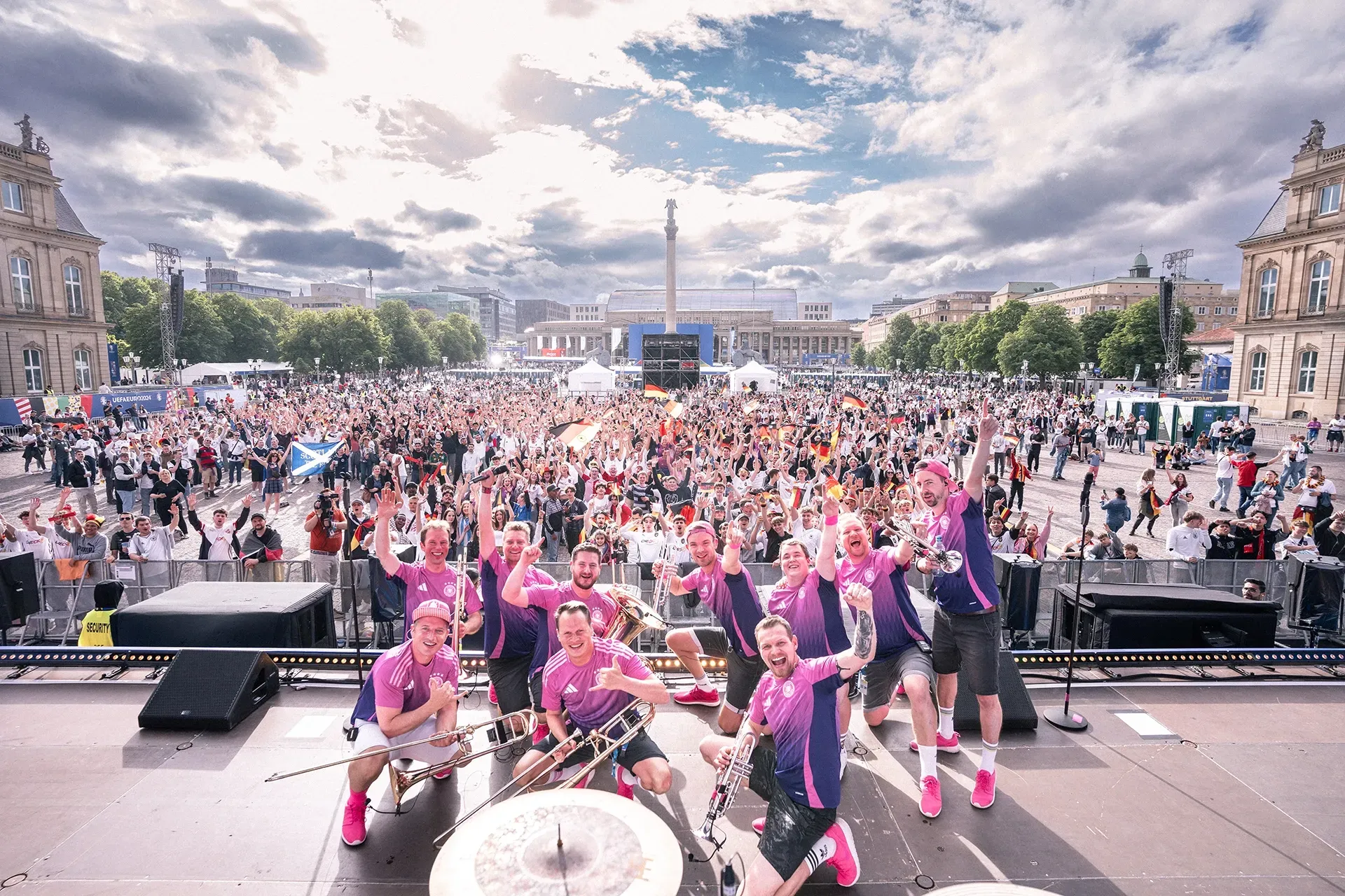 Eine Gruppe von Menschen steht vor einer Menschenmenge auf einer Bühne.