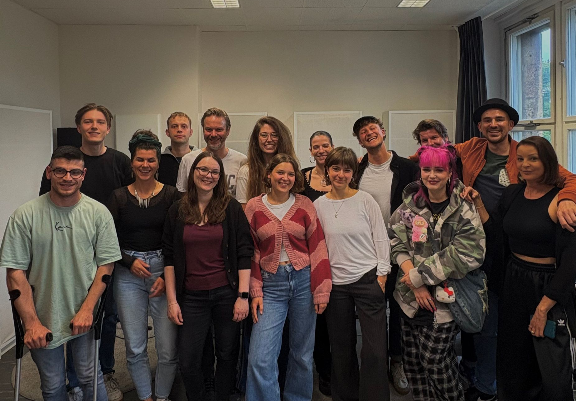 Gruppenfoto der Songcamp Teilnehmer:innen im Studio, während alle lächeln.