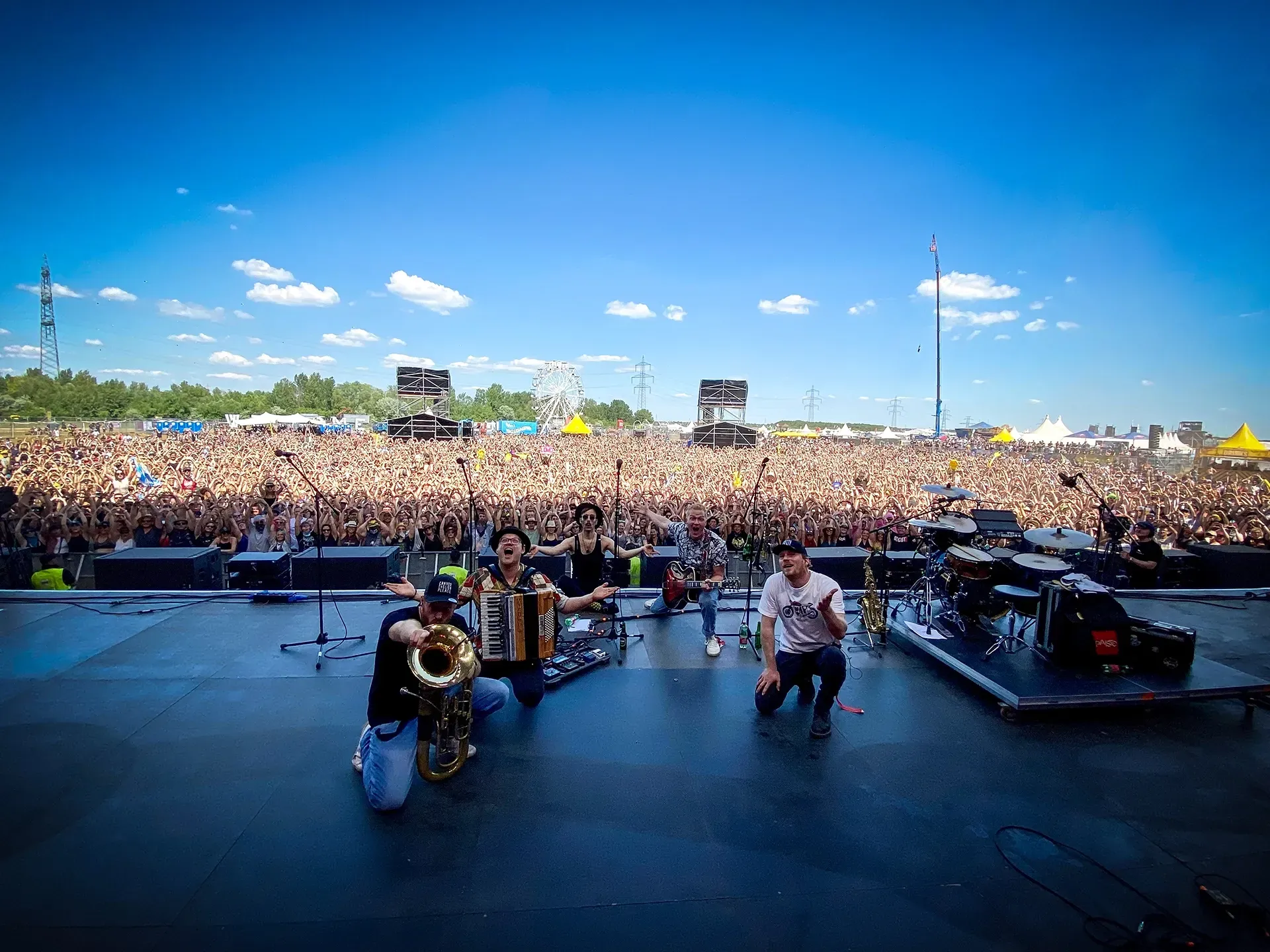 Bei einem Konzert steht eine Gruppe von Menschen vor einem Publikum auf einer Bühne.
