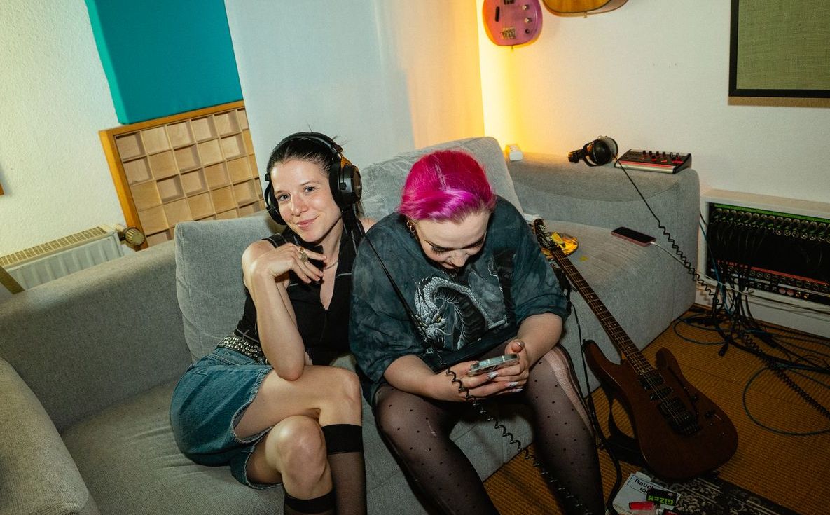 Eine Gruppe von Menschen sitzt auf einem Sofa in einem Wohnzimmer.