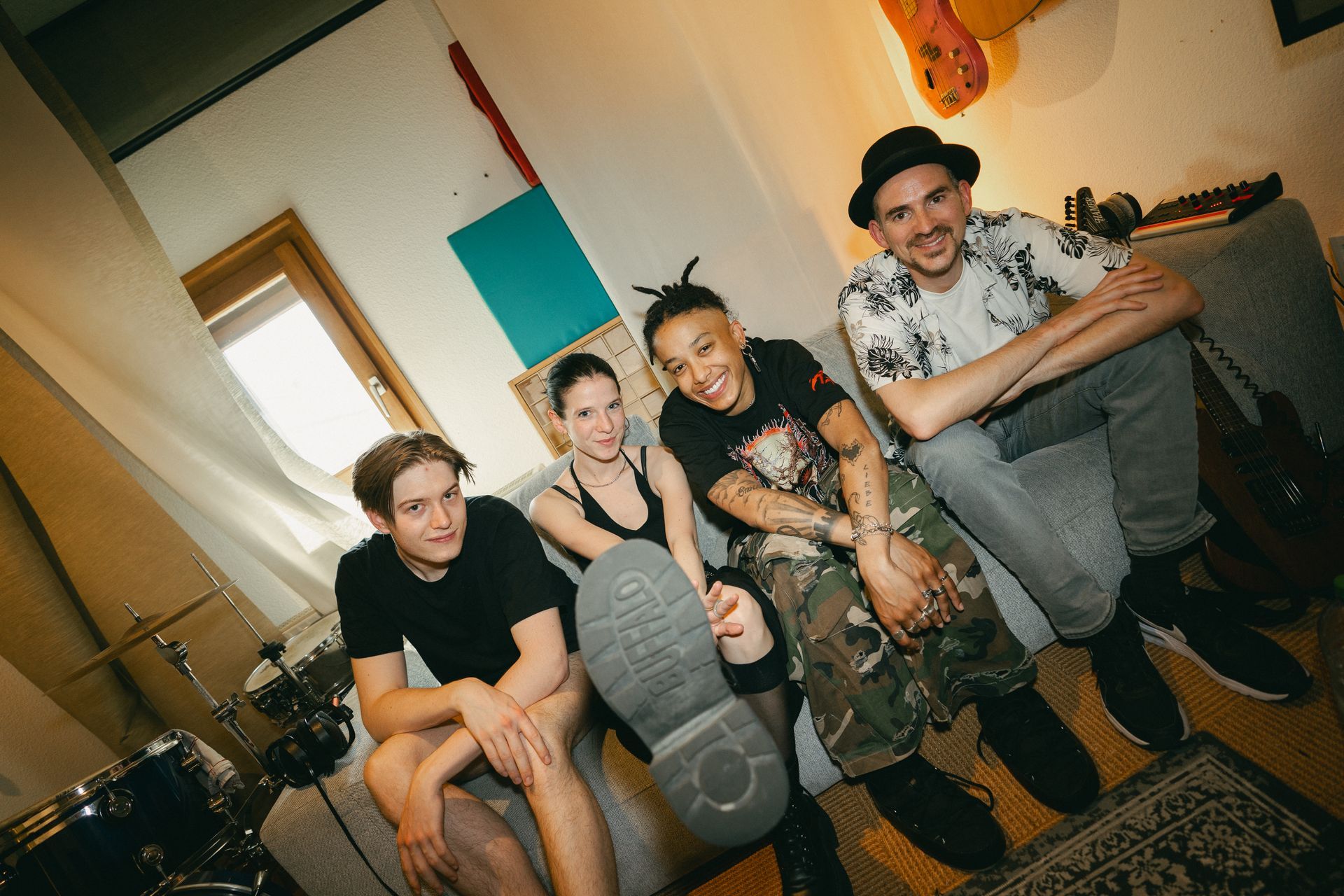 Drei Personen sitzen an einem Mischpult in einem Aufnahmestudio.