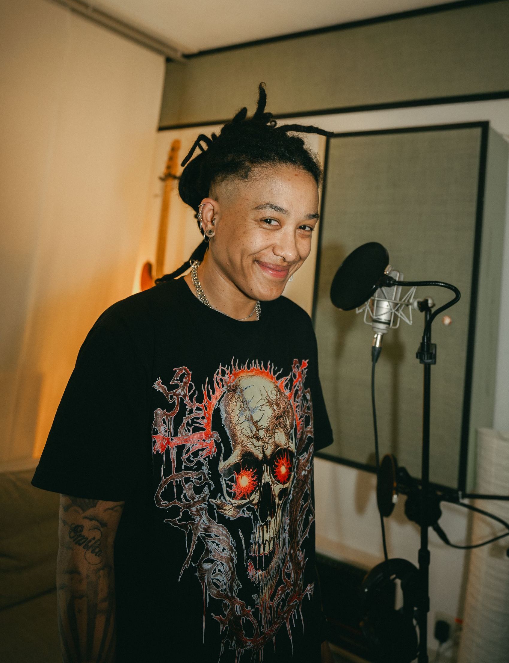 Eine Frau singt in einem Aufnahmestudio in ein Mikrofon.