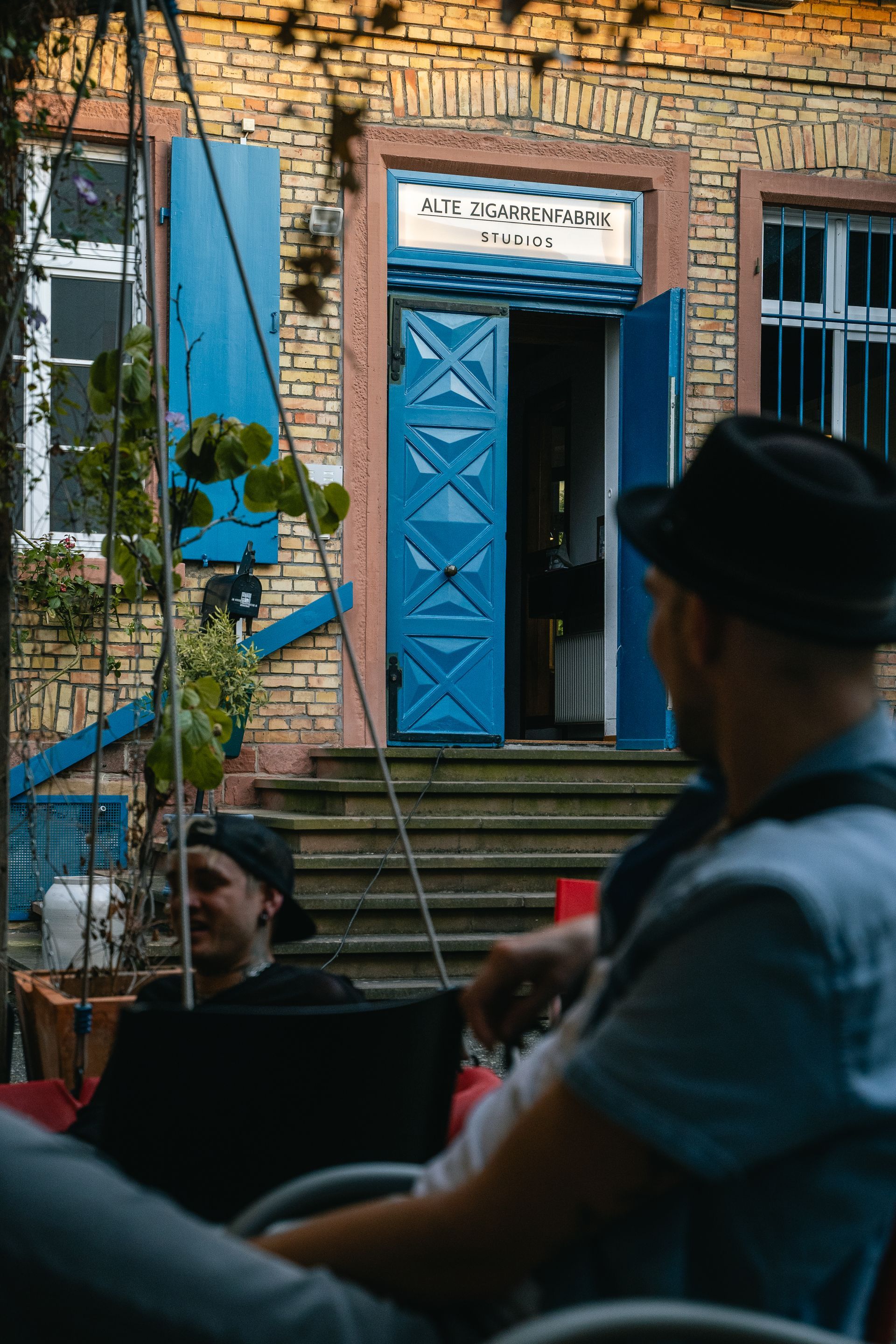 Ein Mann sitzt an einem Schreibtisch vor einem Computer und einer Tastatur.