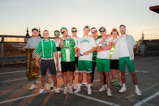 Eine Gruppe junger Männer posiert auf einem Parkplatz für ein Foto.