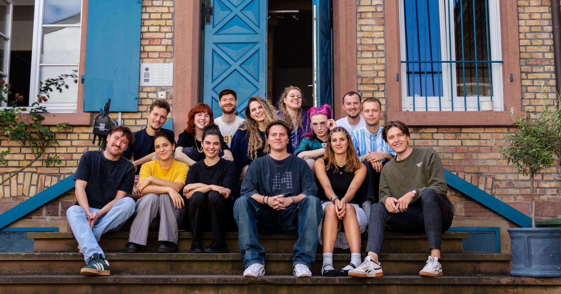 Gruppenbild der Teilnehmer:innen des Newcomer:innen Camps auf den Stufen der 