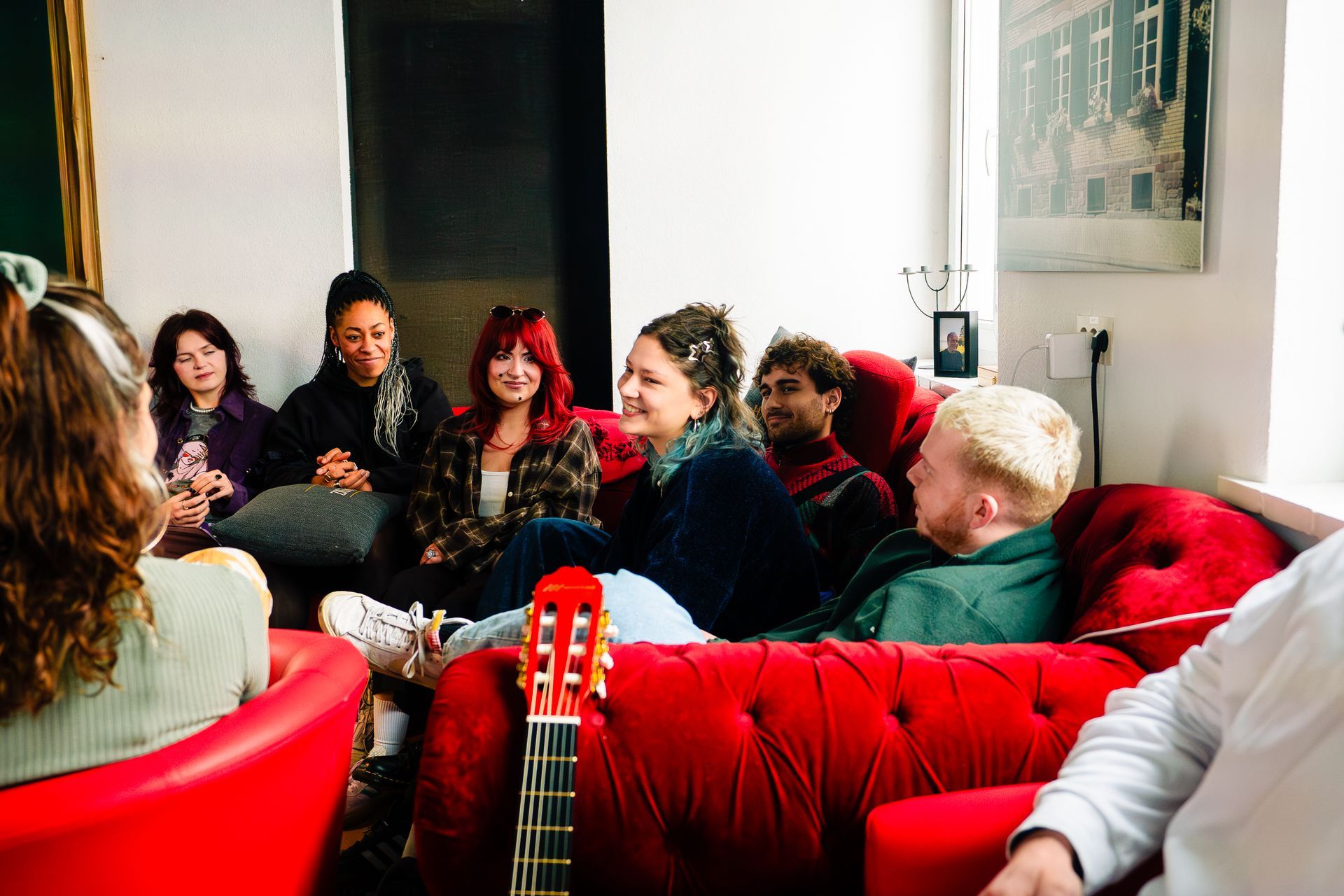 Eine Gruppe der Künstler sitzen auf dem Sofa und lachen.
