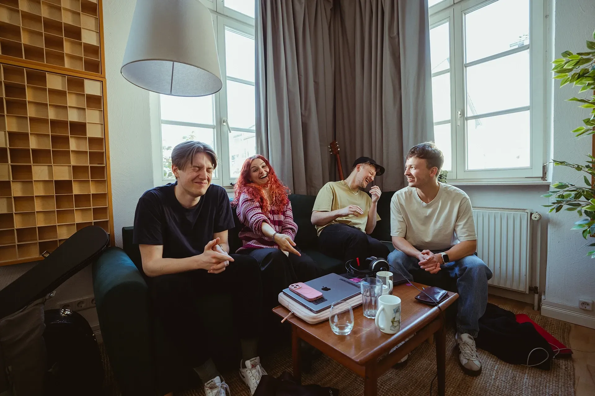 Eine Gruppe von Menschen sitzt auf einem Sofa in einem Wohnzimmer.