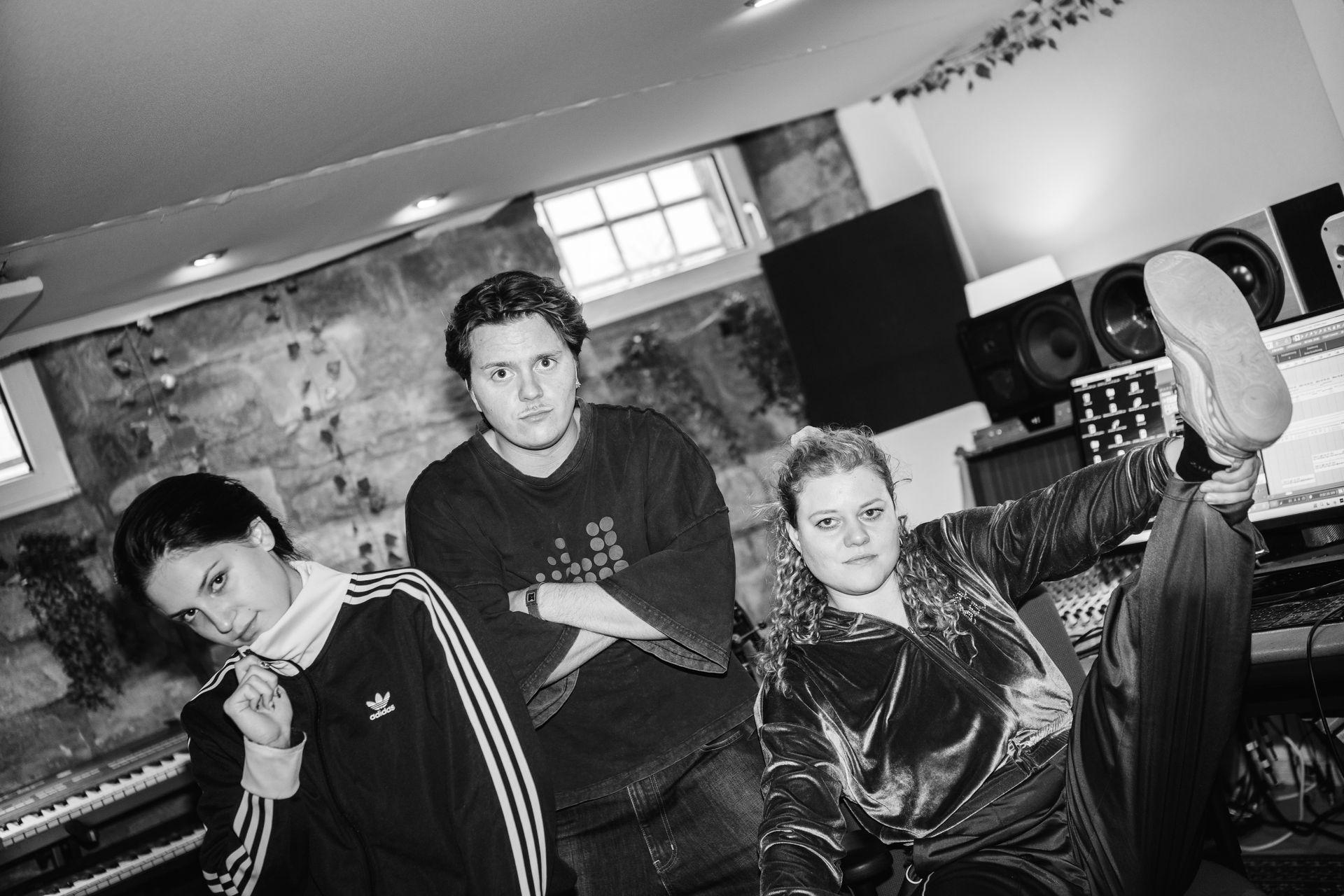 Drei Teilnehmer posieren im Studio für die Kamera.