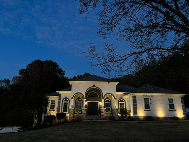 A house is lit up at night with a full moon in the sky.