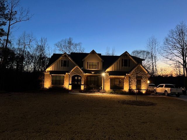 A large red brick house is lit up at night