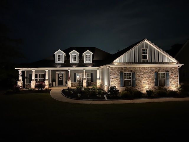 A large brick house is lit up at night.