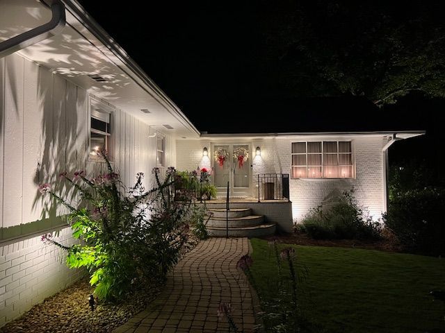 A large brick house is lit up at night.