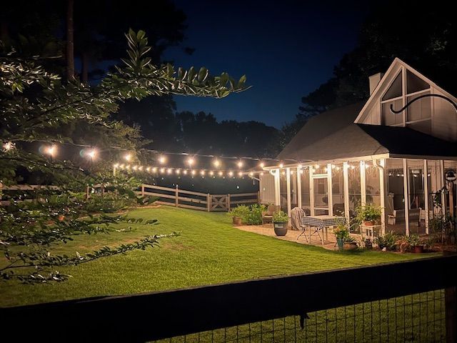 A house is lit up at night with a string of lights hanging from the roof.