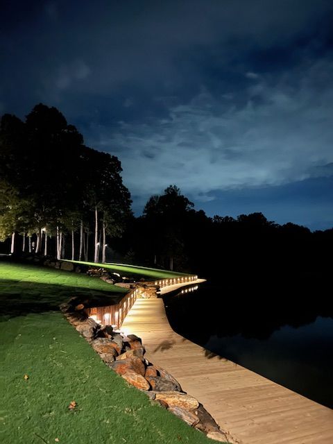 A wooden walkway leading to a lake at night
