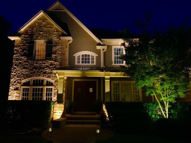 The front of a house is lit up at night