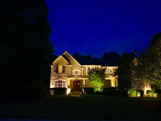A large house is lit up at night with lots of lights.