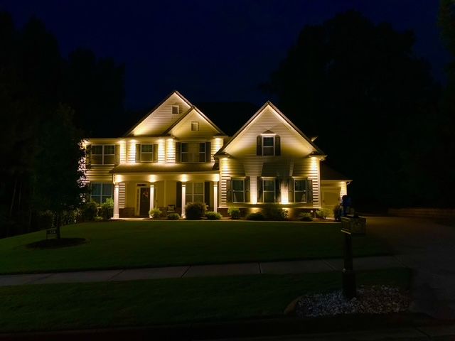 A large house is lit up at night.