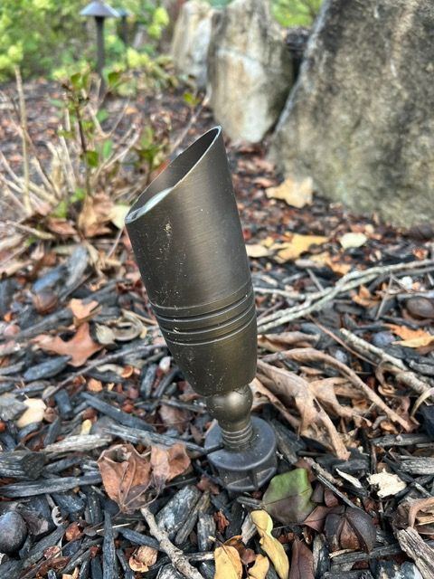 A small light is sitting on top of a pile of mulch.
