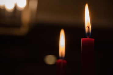 Due candele rosse sono accese nel buio