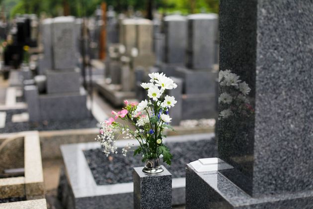 Un vaso di fiori è posto su una tomba in un cimitero.