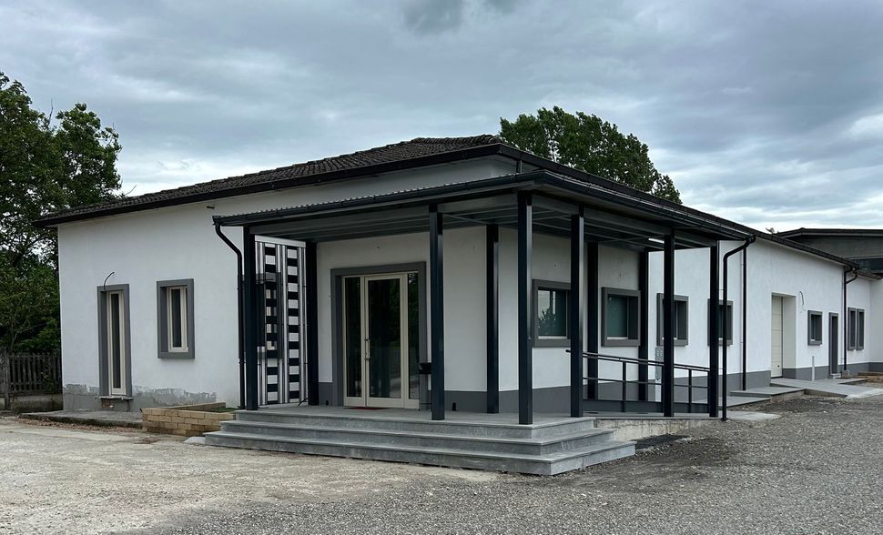 Una casa bianca con un portico e delle scale davanti