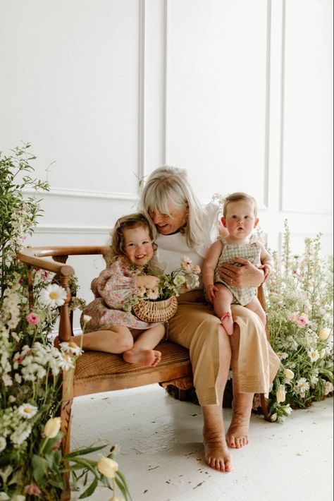 A grandmother and her grandchildren sitting on a bench laughing.