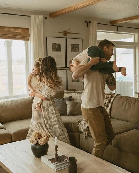 A man is carrying a child on his shoulders in a living room.