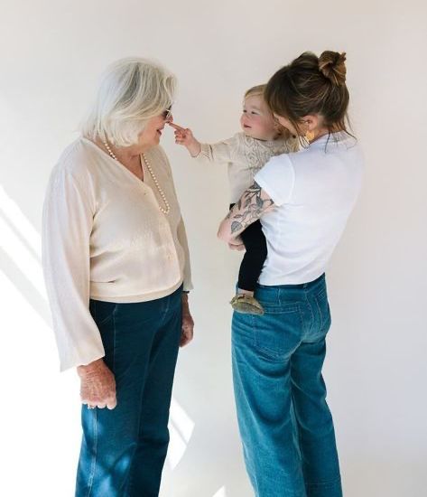 A woman is holding a baby while another woman looks on.
