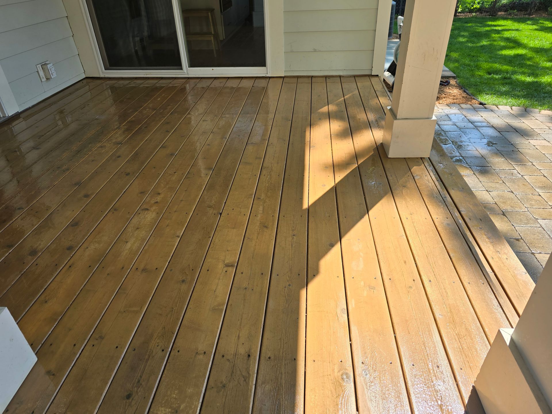 A wooden deck with a white house in the background