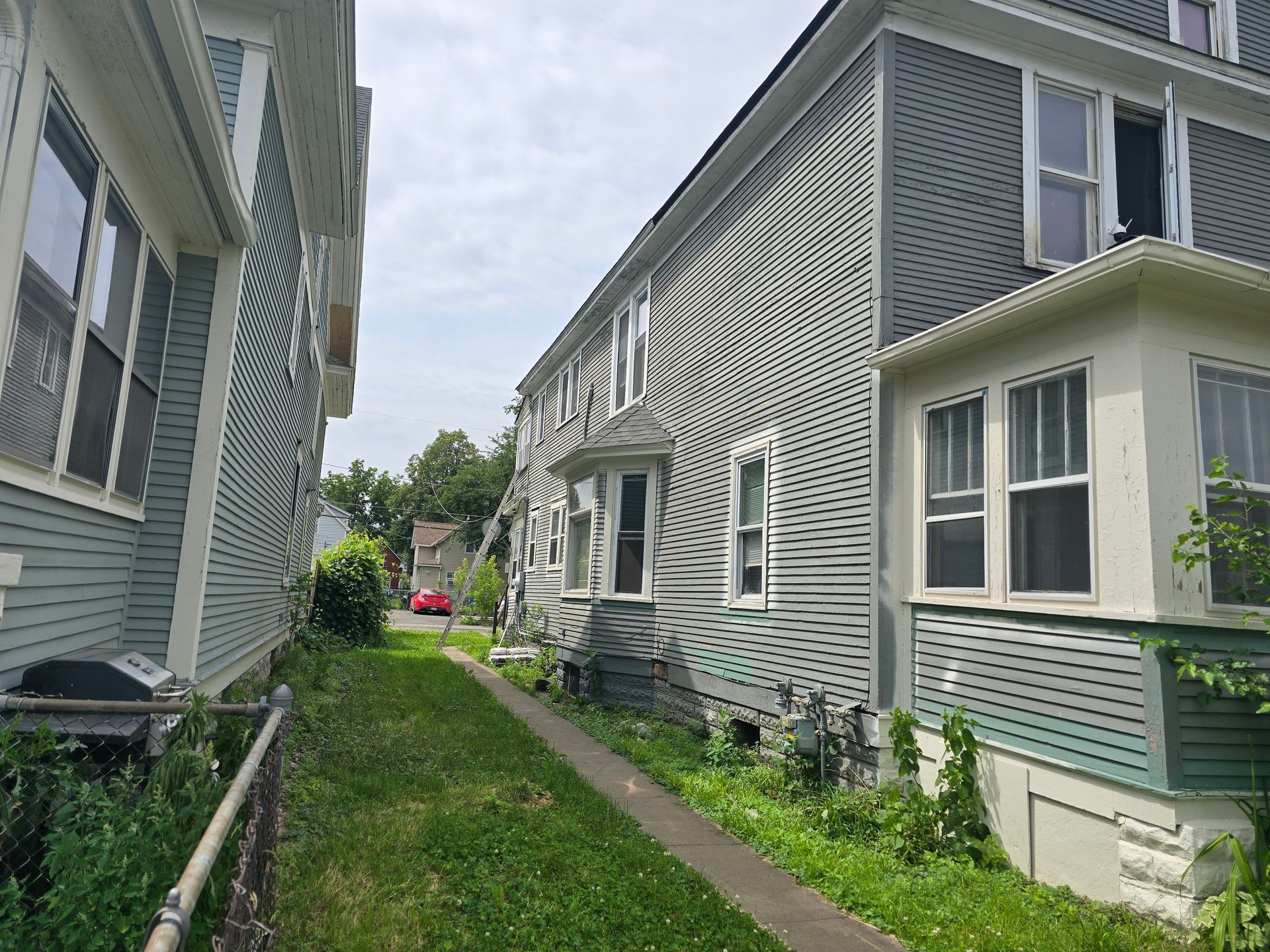A row of houses with a sidewalk between them.