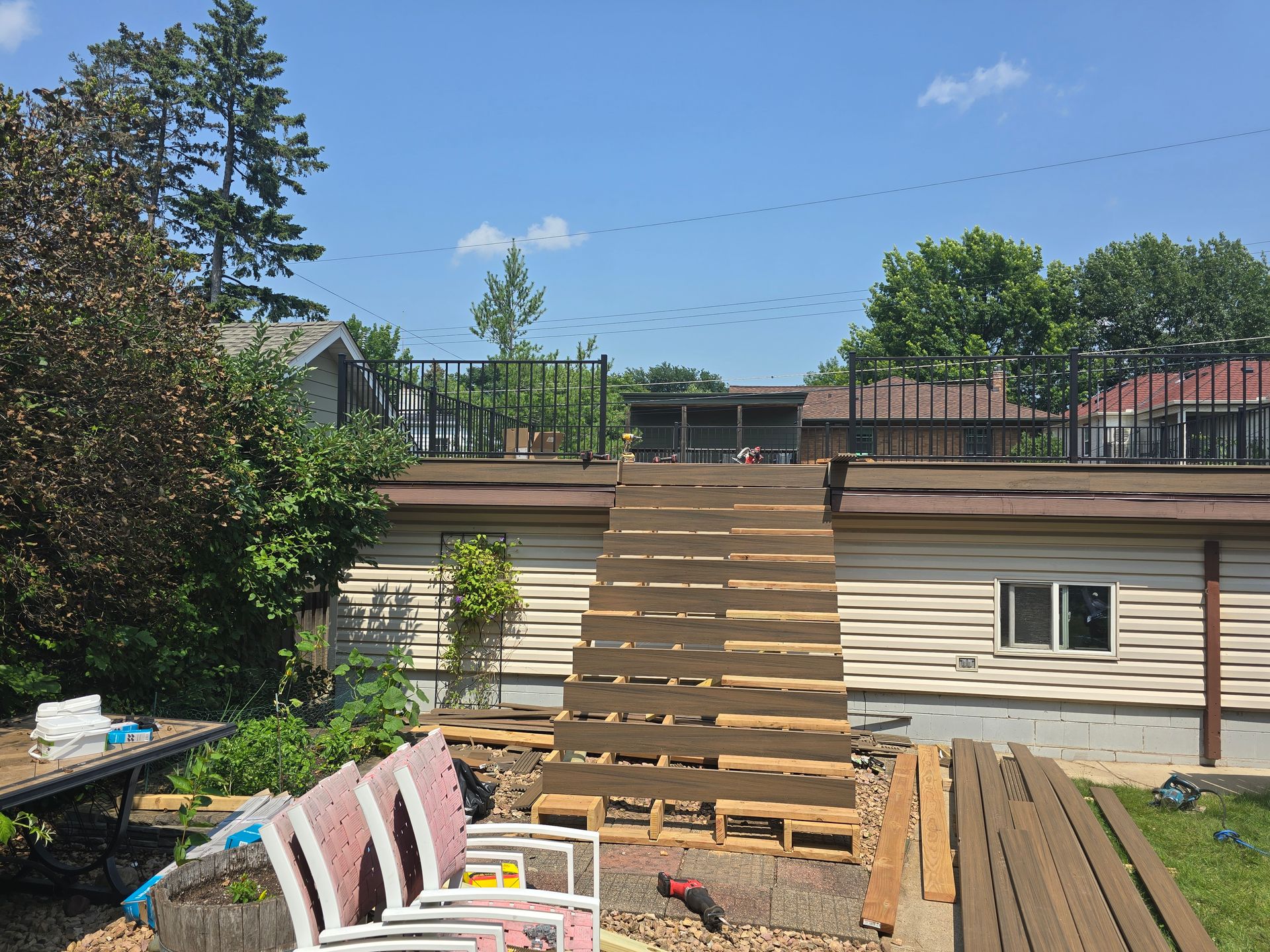 A wooden deck is being built in the backyard of a house.